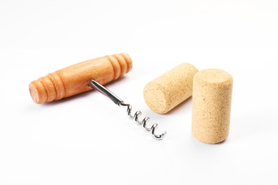 Photo of Corkscrew with wooden handle and corks on white background