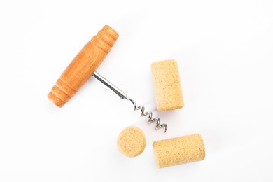 Photo of Corkscrew and corks on white background, top view