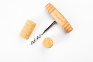 Photo of Corkscrew and corks on white background, top view