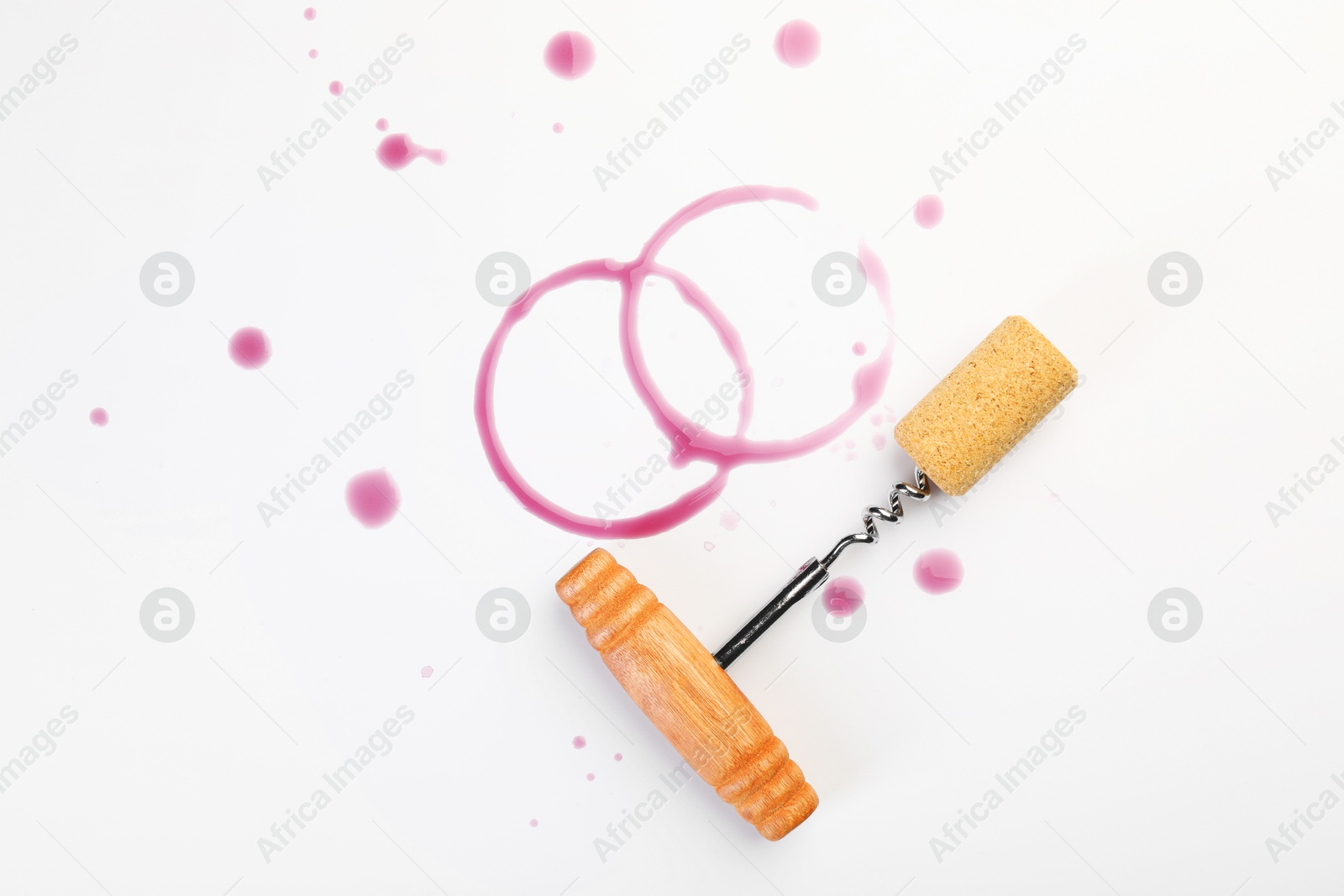 Photo of Corkscrew, cork and red wine stains on white background, top view