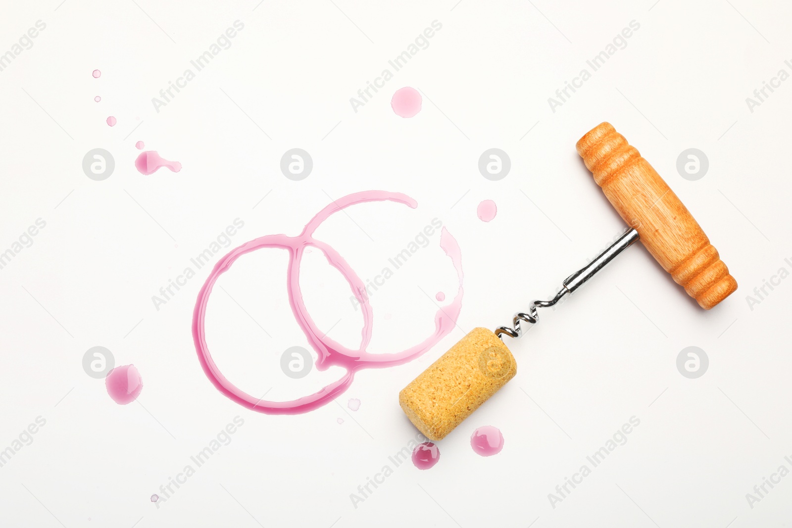 Photo of Corkscrew, cork and red wine stains on white background, top view