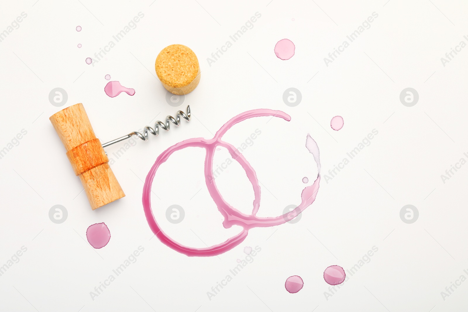 Photo of Corkscrew, cork and red wine stains on white background, top view