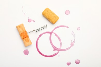 Photo of Corkscrew, cork and red wine stains on white background, top view