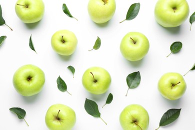 Photo of Green apples and leaves on white background, flat lay