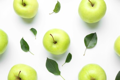 Photo of Green apples and leaves on white background, flat lay