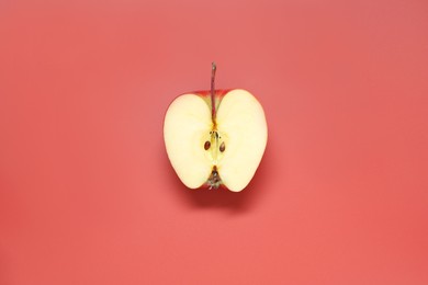 Photo of Half of fresh ripe apple on red background, top view