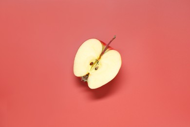 Photo of Half of fresh ripe apple on red background, top view