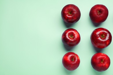 Photo of Fresh ripe red apples on light blue background, flat lay. Space for text