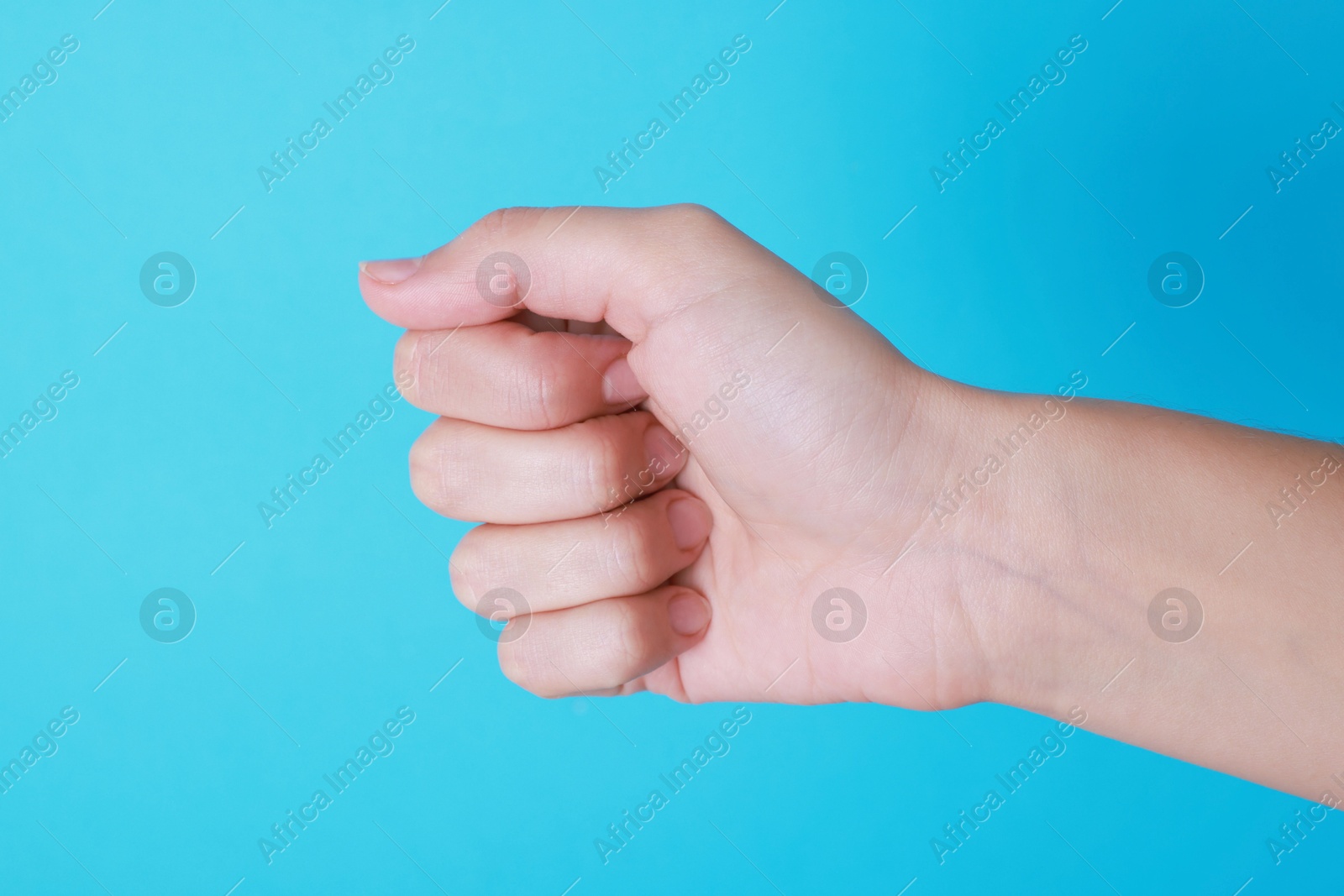 Photo of Woman with visible hand veins on light blue background, closeup