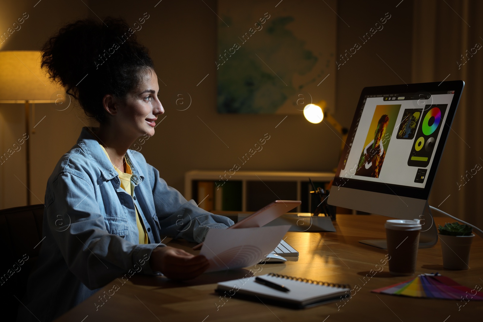 Photo of Designer with tablet and color palette working indoors at night