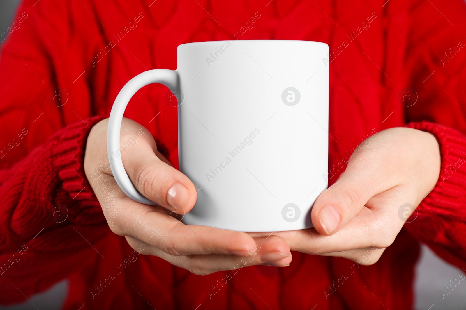 Photo of Woman holding blank white ceramic mug, closeup. Mockup for design