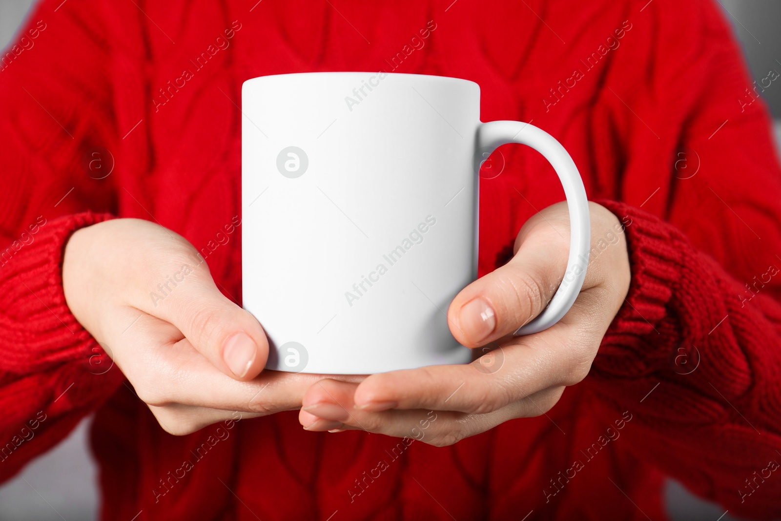 Photo of Woman holding blank white ceramic mug, closeup. Mockup for design