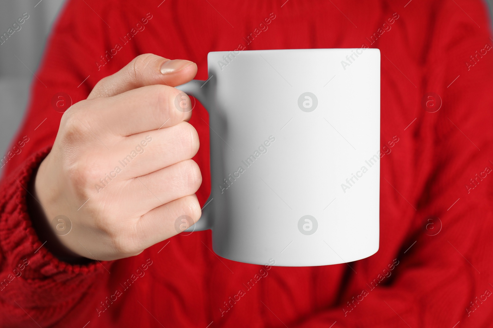 Photo of Woman holding blank white ceramic mug, closeup. Mockup for design