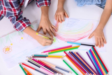 Photo of Children drawing at white table, above view