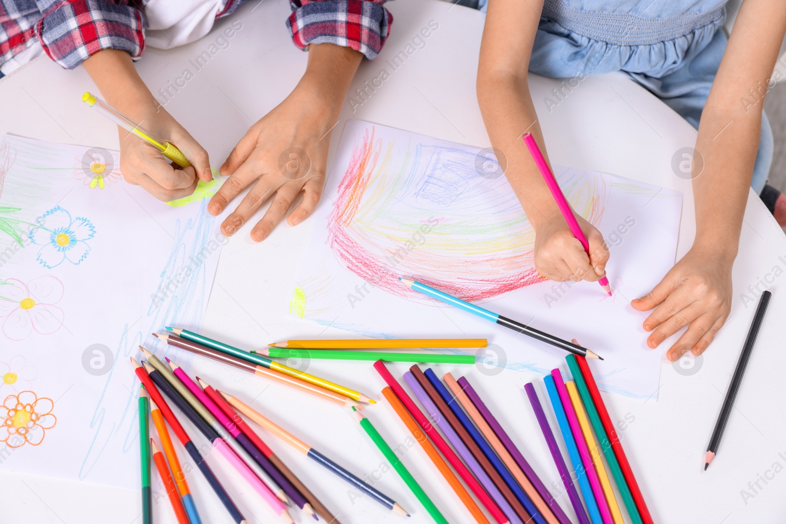 Photo of Children drawing at white table, above view