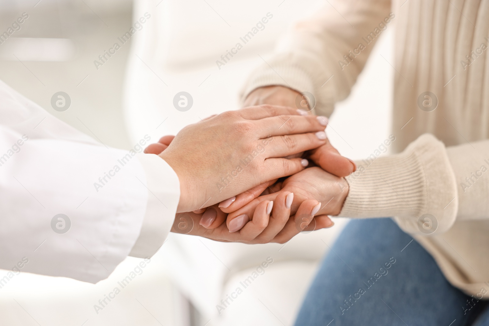 Photo of Doctor supporting patient during appointment in hospital, closeup of hands