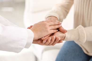 Photo of Doctor supporting patient during appointment in hospital, closeup of hands