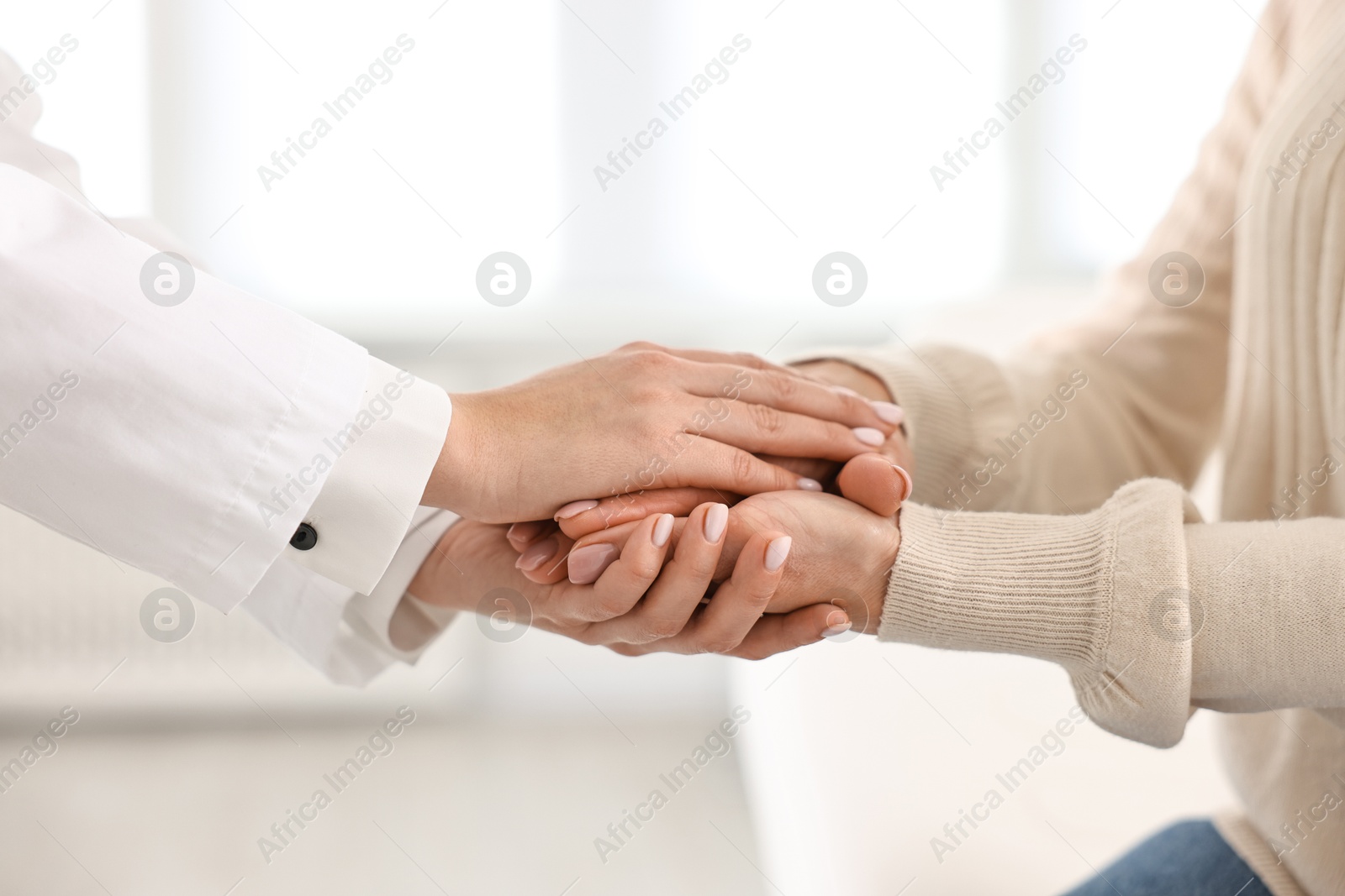 Photo of Doctor supporting patient during appointment in hospital, closeup of hands