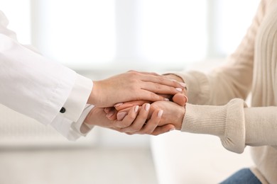 Photo of Doctor supporting patient during appointment in hospital, closeup of hands