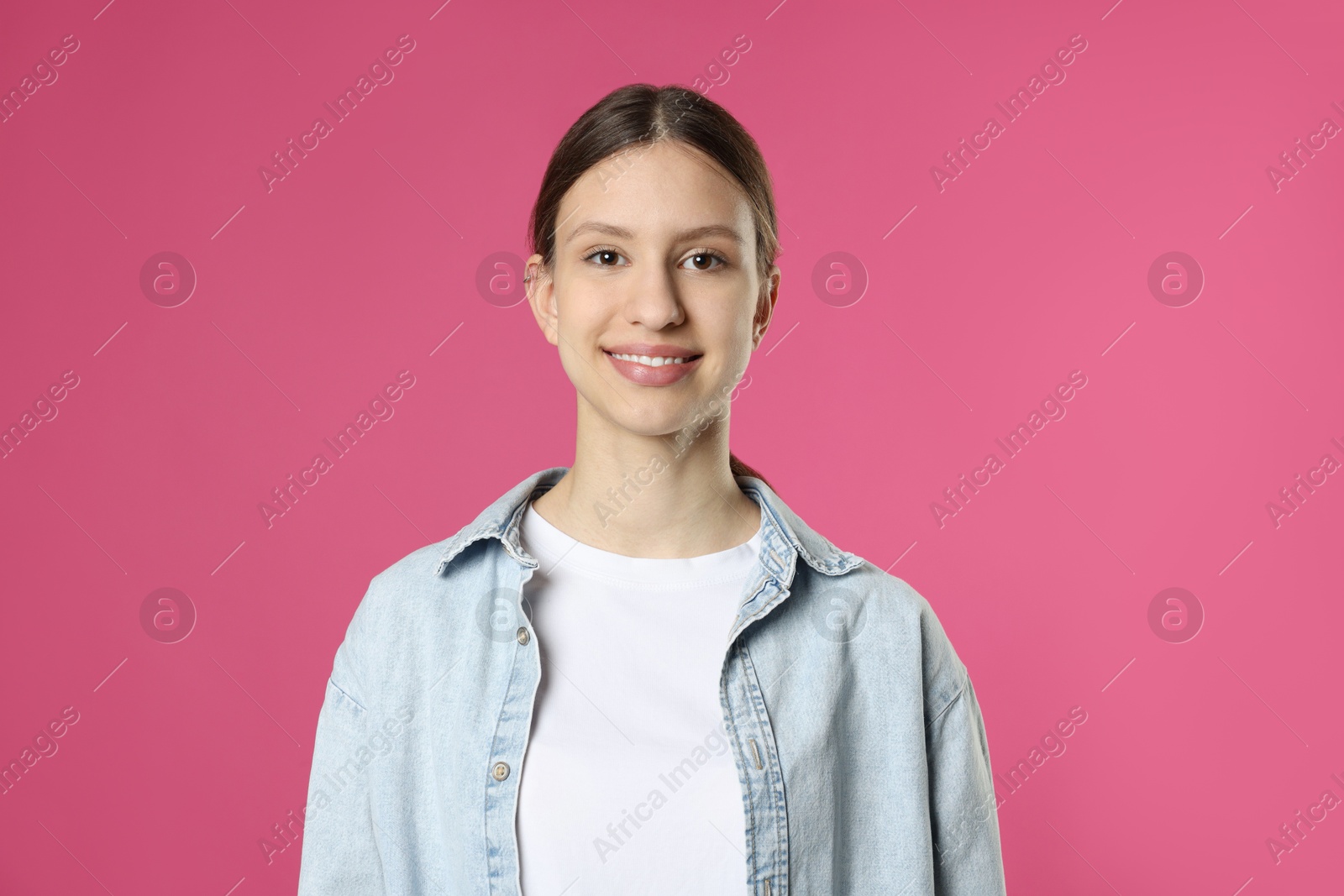 Photo of Portrait of smiling teenage girl on pink background