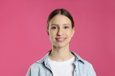 Photo of Portrait of smiling teenage girl on pink background