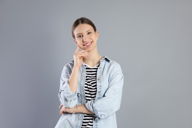 Photo of Portrait of smiling teenage girl on grey background