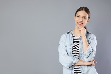 Photo of Portrait of smiling teenage girl on grey background. Space for text