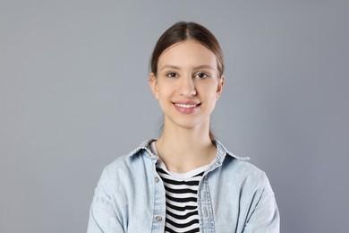 Photo of Portrait of smiling teenage girl on grey background