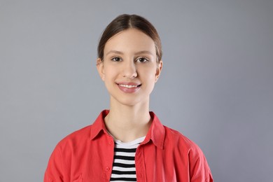 Photo of Portrait of smiling teenage girl on grey background