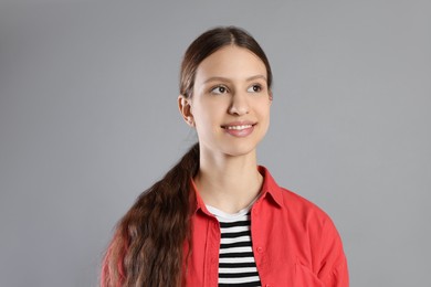 Photo of Portrait of smiling teenage girl on grey background