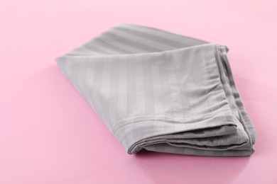 Photo of Stacked clean bed linens on pink background