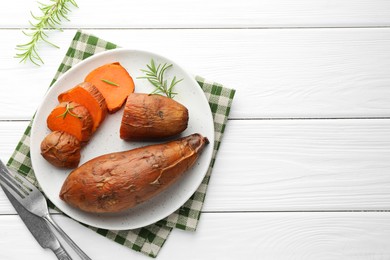 Tasty cooked sweet potatoes served with rosemary on white wooden table, top view. Space for text