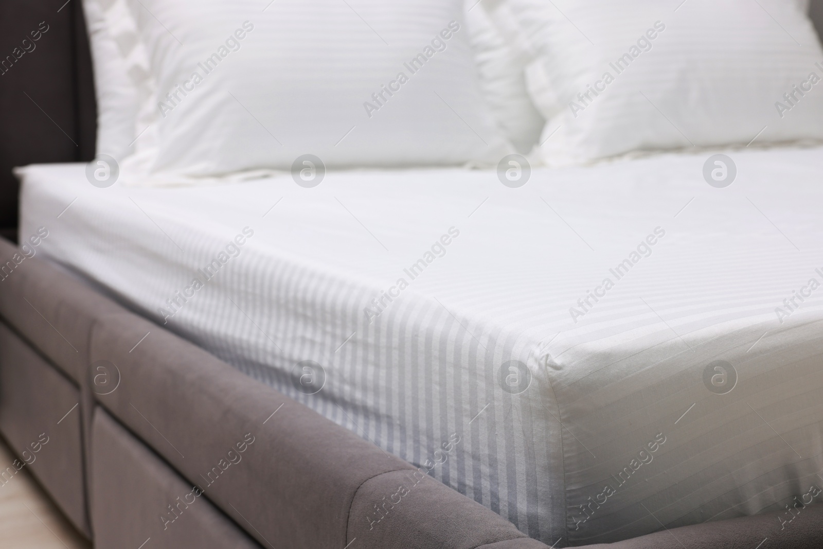 Photo of Bed with clean linens and pillows indoors, closeup