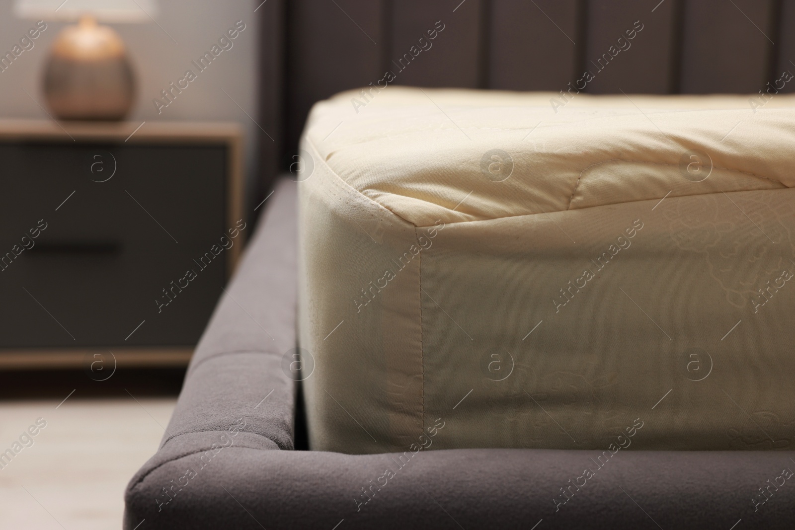 Photo of Comfortable bed with clean linens indoors, closeup view