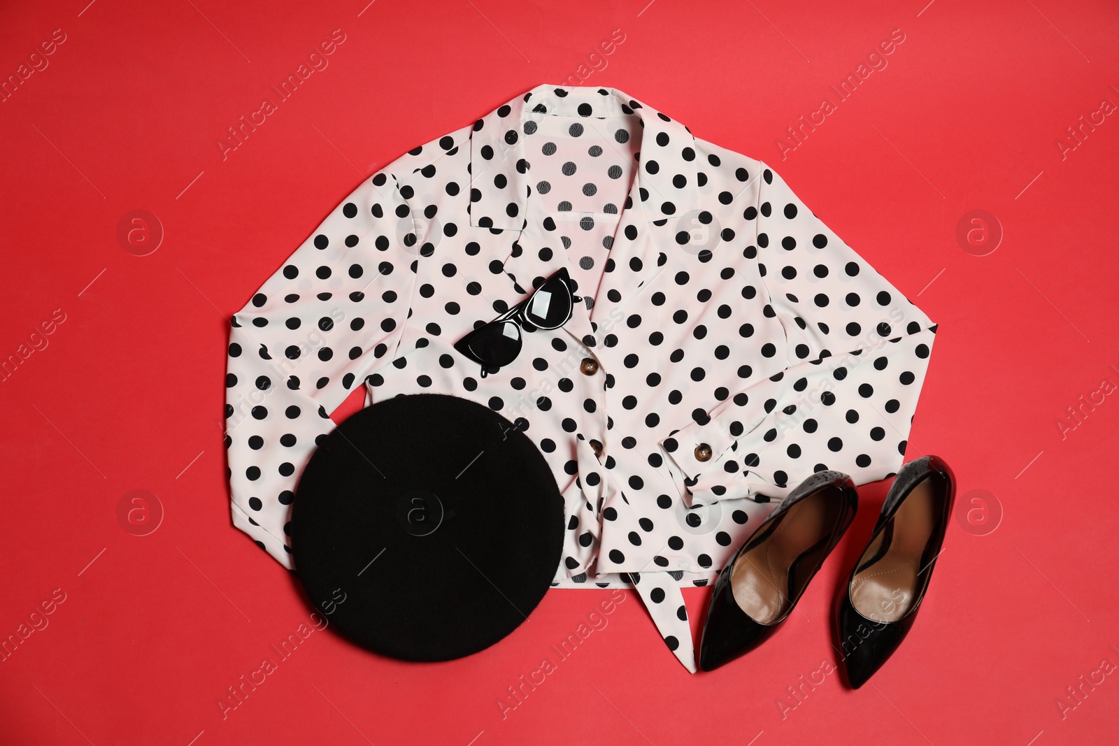 Photo of Retro styled outfit on red background, flat lay