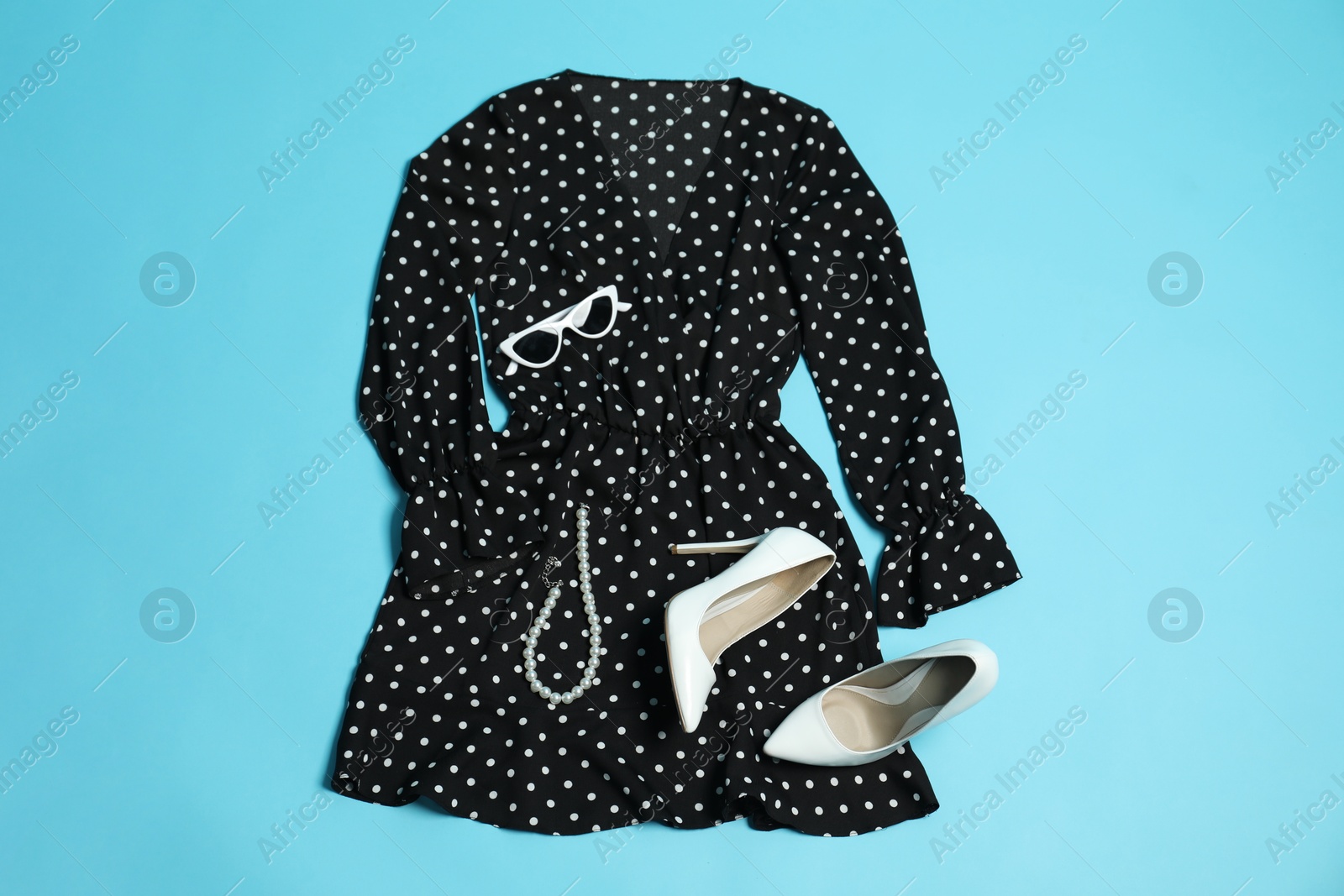 Photo of Retro styled outfit on light blue background, flat lay