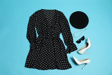 Photo of Retro styled outfit on light blue background, flat lay