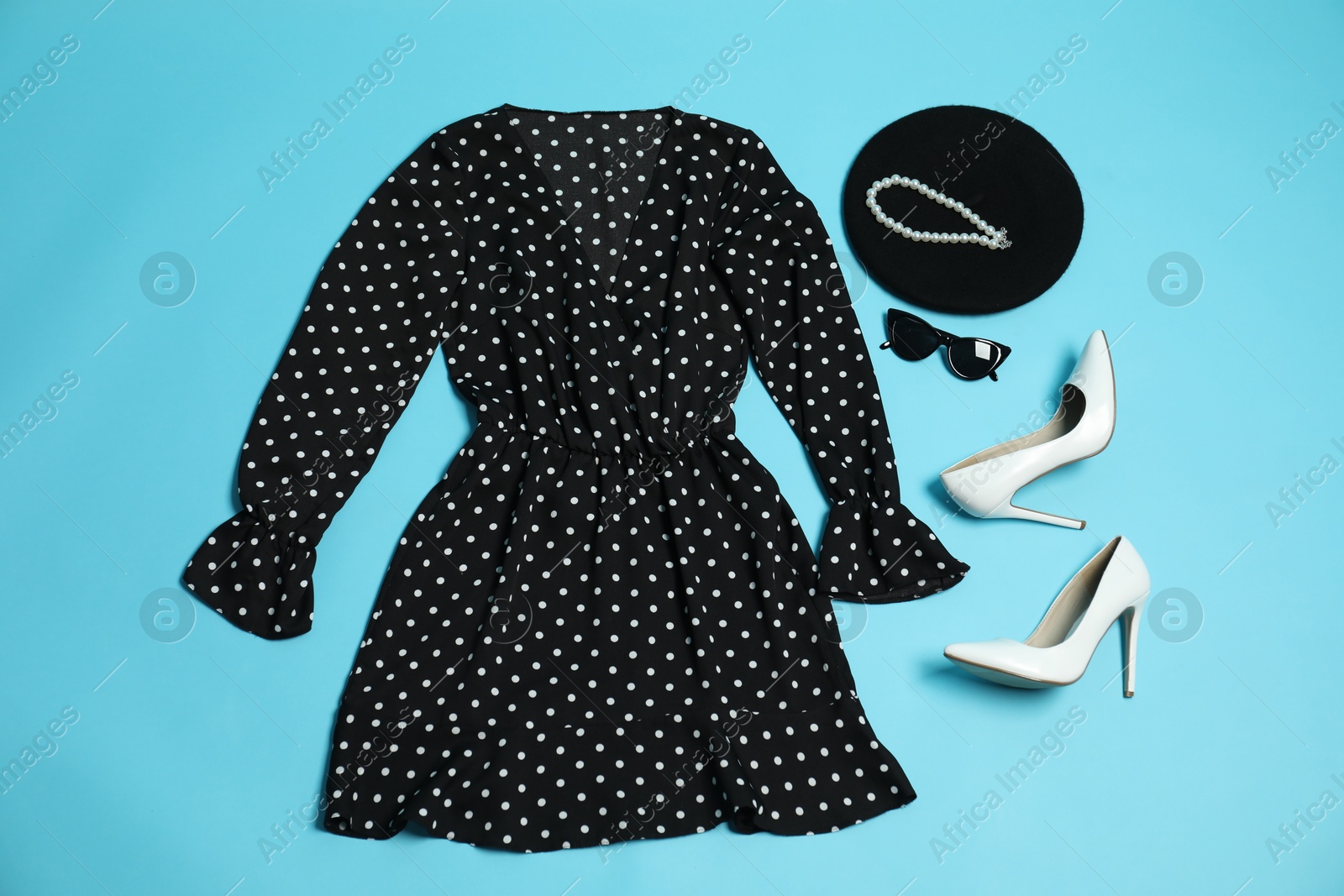 Photo of Retro styled outfit on light blue background, flat lay