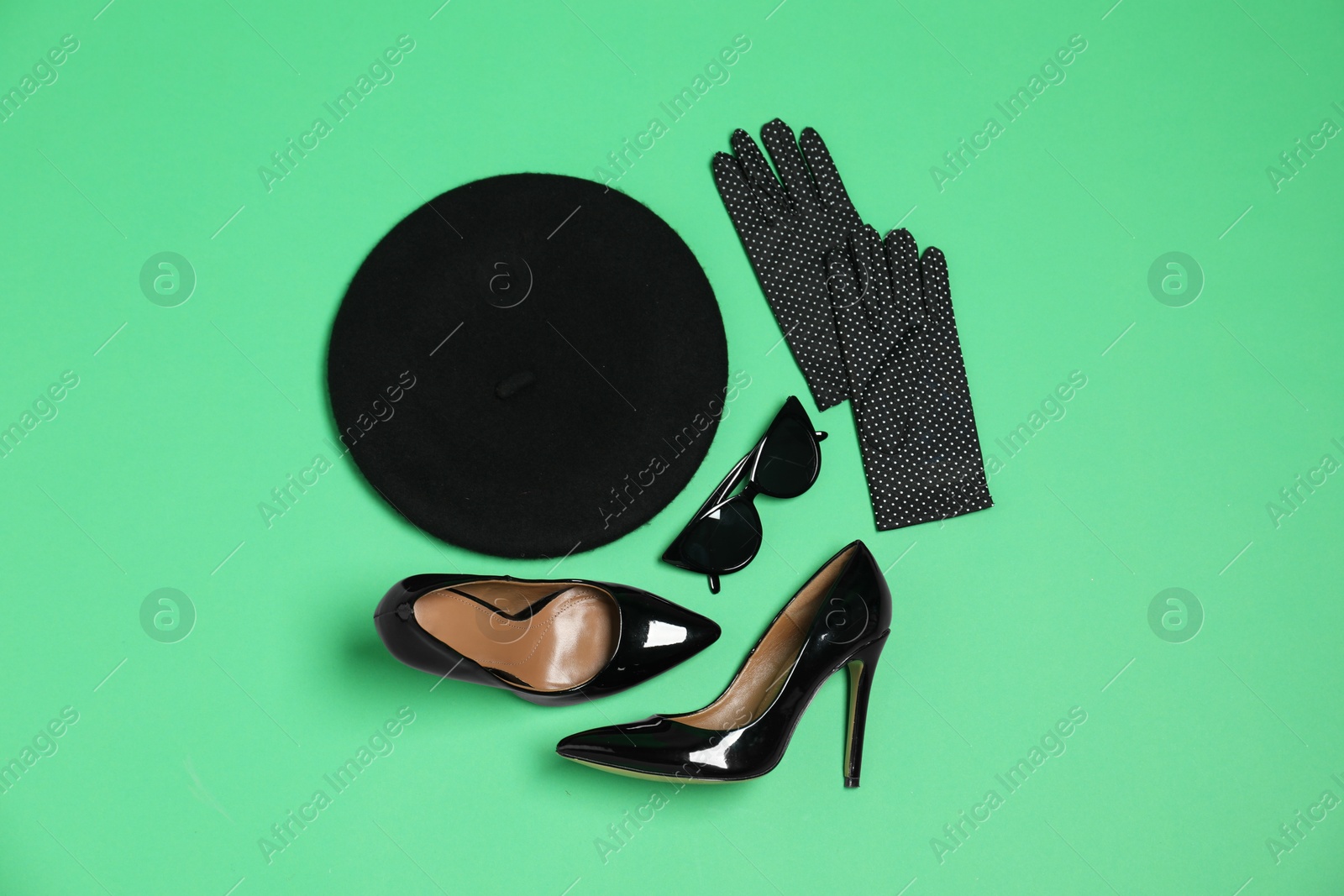 Photo of Stylish accessories on green background, flat lay