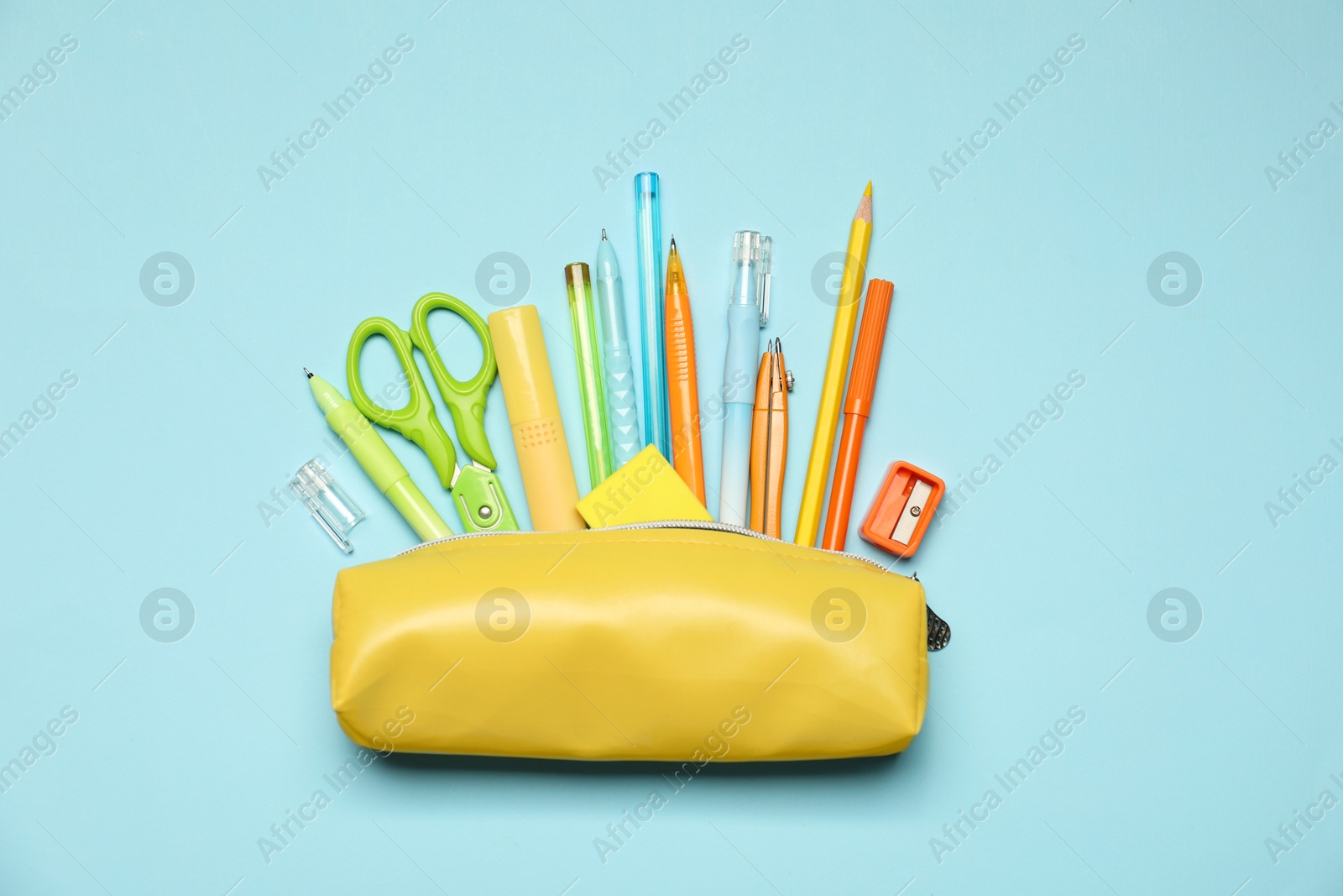 Pencil case and different stationery on light blue background, flat lay Photo of Pencil case and different stationery on light blue background, flat lay