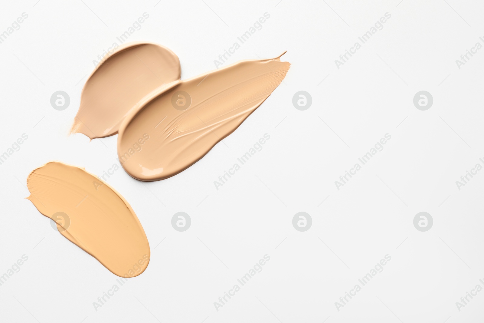 Photo of Samples of foundations on white background, top view