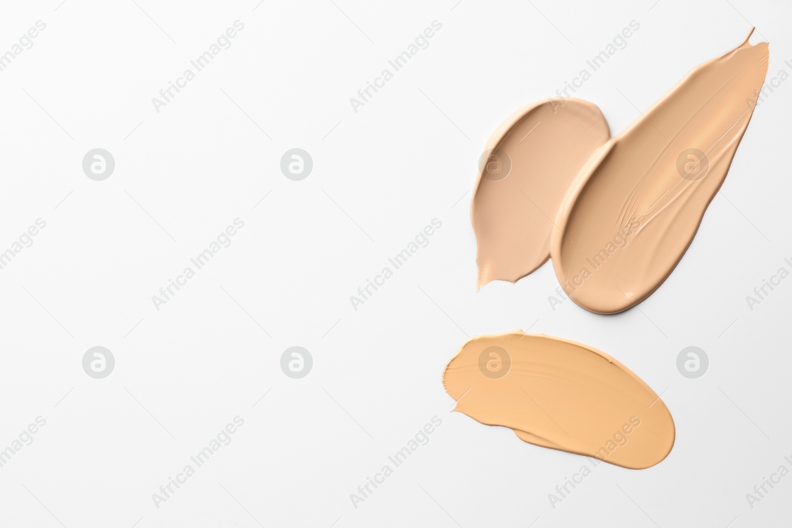 Photo of Samples of foundations on white background, top view