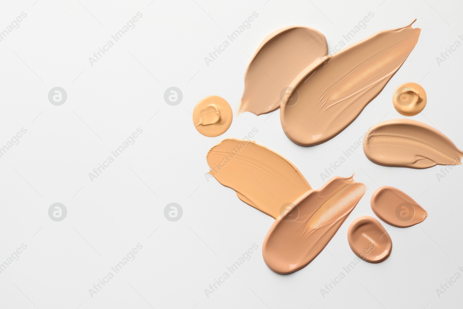 Photo of Samples of foundations on white background, top view