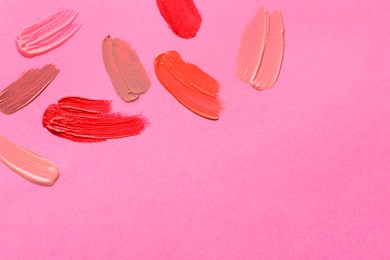 Photo of Samples of different lip products on pink background, top view. Space for text