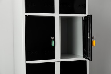 Photo of Open lockers with keys on light background, closeup