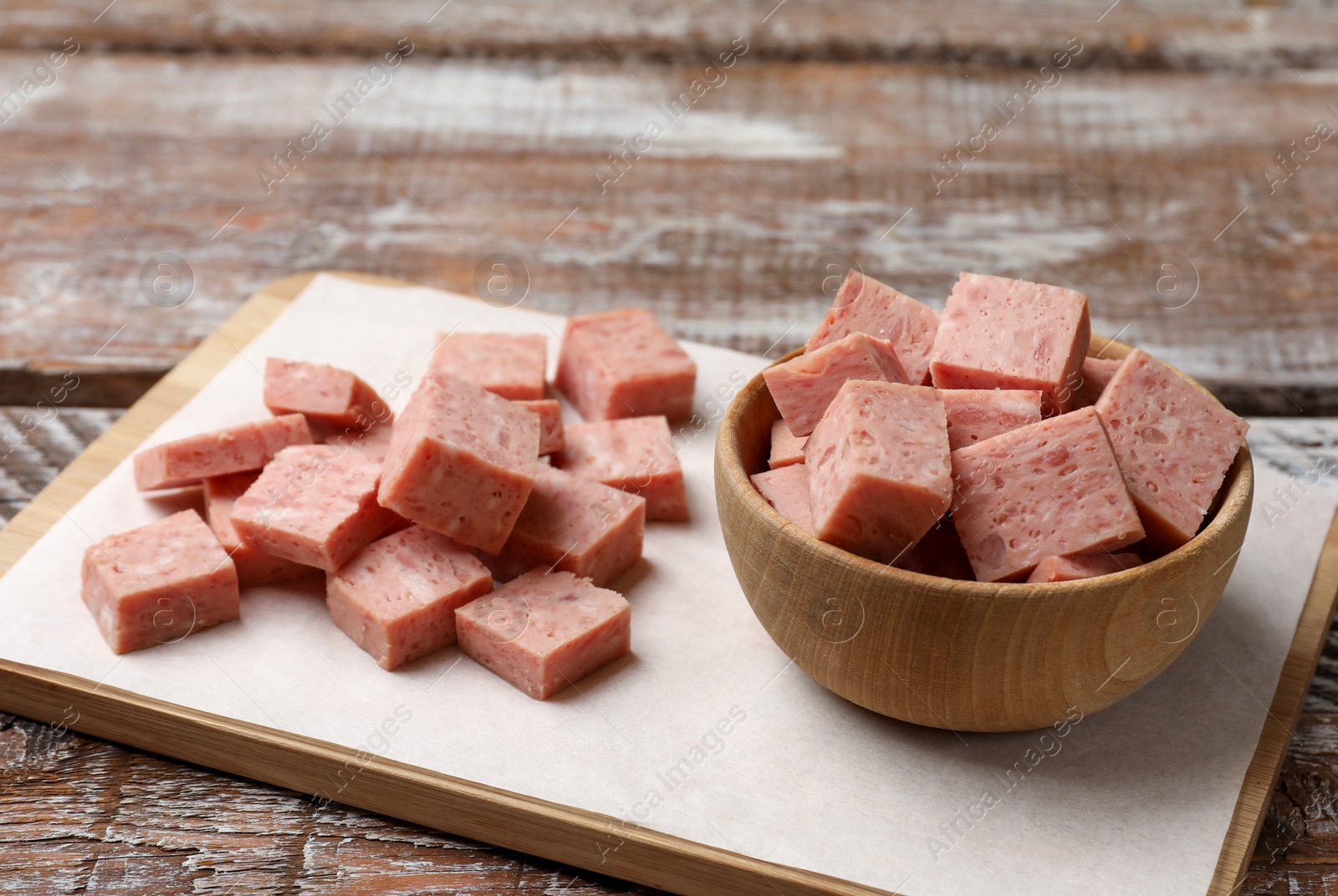 Photo of Pieces of canned meat on wooden table, closeup