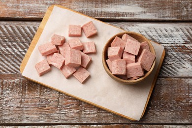 Photo of Pieces of canned meat on wooden table, top view