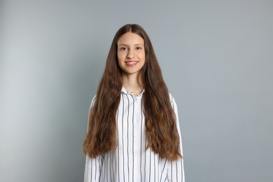 Photo of Teenage girl with healthy long hair on light grey background