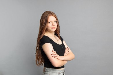 Photo of Teenage girl with healthy long hair on light grey background