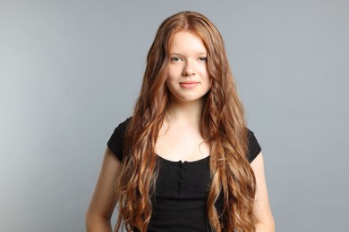 Photo of Teenage girl with healthy long hair on light grey background